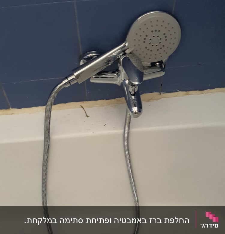 ברז מקלחת עם צינור ומזלף על קיר כחול
